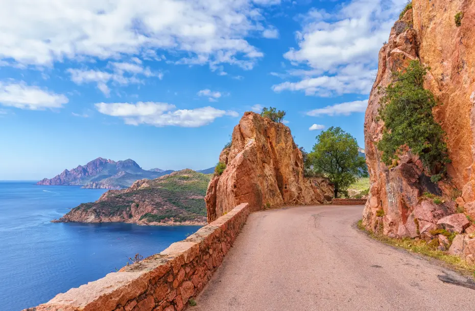 Strada di montagna colorata con vista mare da un lato, nelle Calanques de Piana in Corsica, Francia
